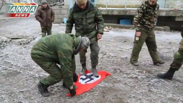 Πολιτοφύλακες, σε απελευθερωμένο χωριό κοντά στο Ντεμπάλτσεβο, τσαλαπατούν τη ναζιστική σημαία που κουβαλούσαν μαζί τους τα ουκρανικά στρατεύματα
